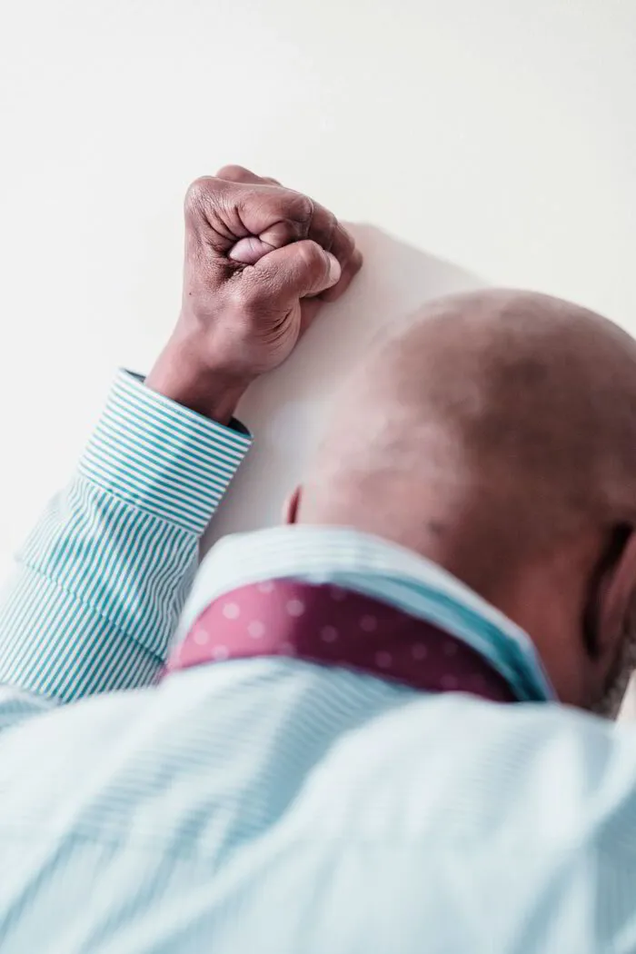 Man against a wall with clenched fist
